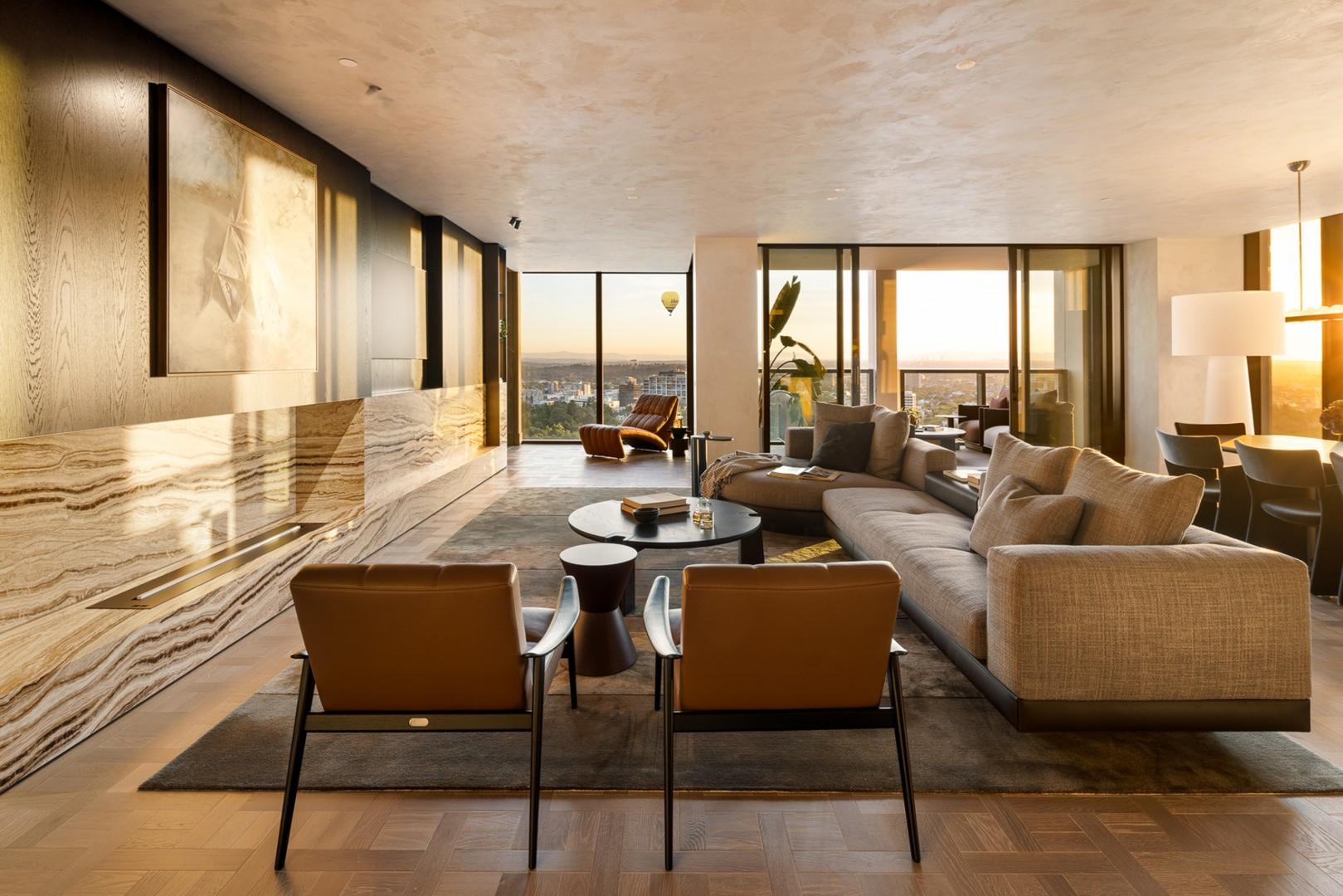 Apartment living room with stone feature wall and sunset views over the parkland
